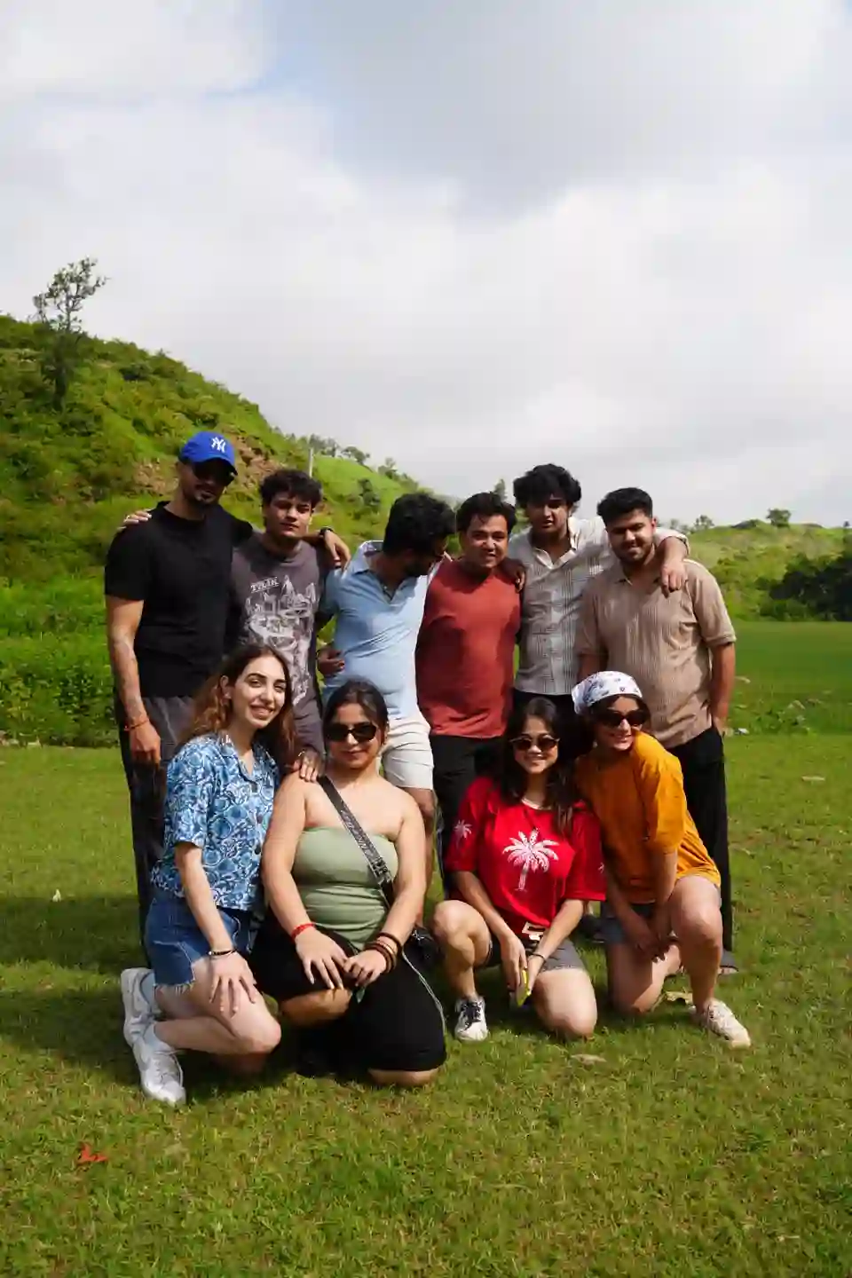 A group of Ora travellers together on a green hillside