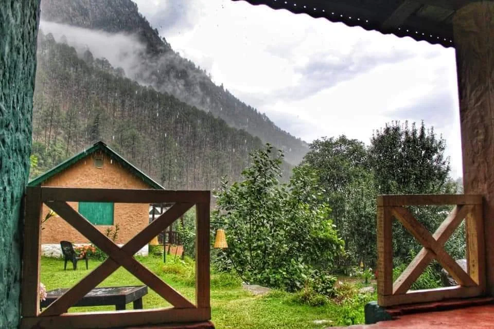 Balcony view across the garden toward forested mountains