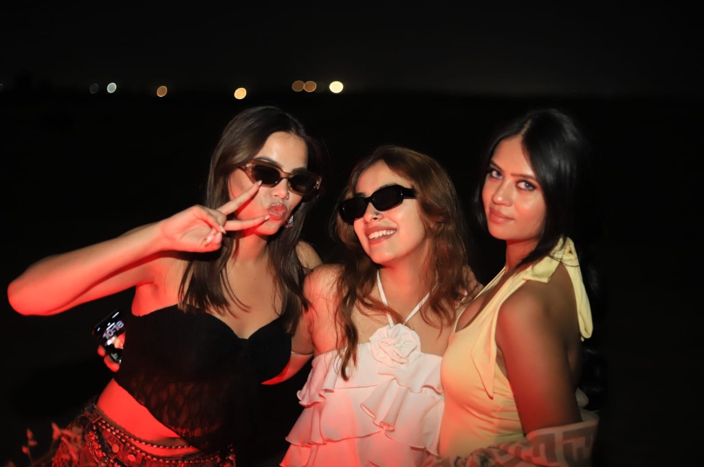 Three friends laughing at a desert night party